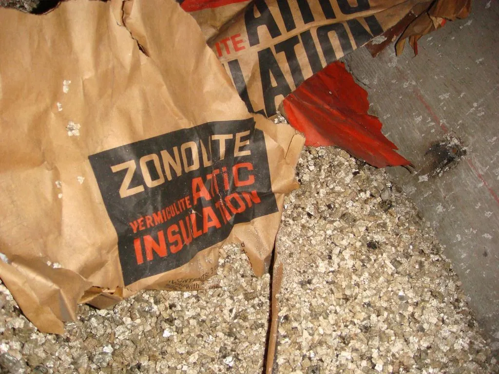 Sac en papier brun étiqueté « Isolation de grenier en zonolite » contenant un matériau isolant en vermiculite.